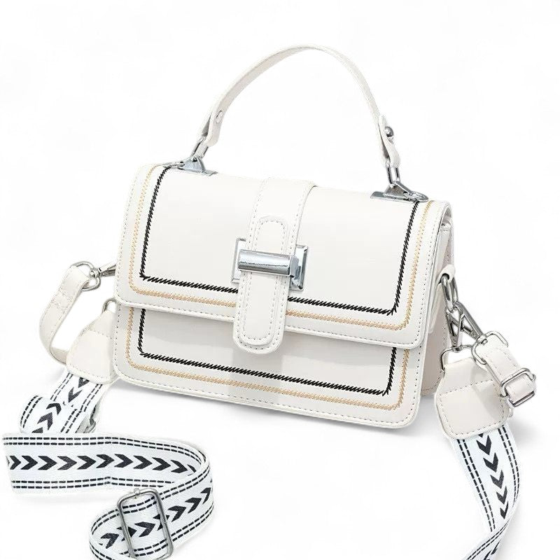 White handbag with black and white patterned strap on a white background