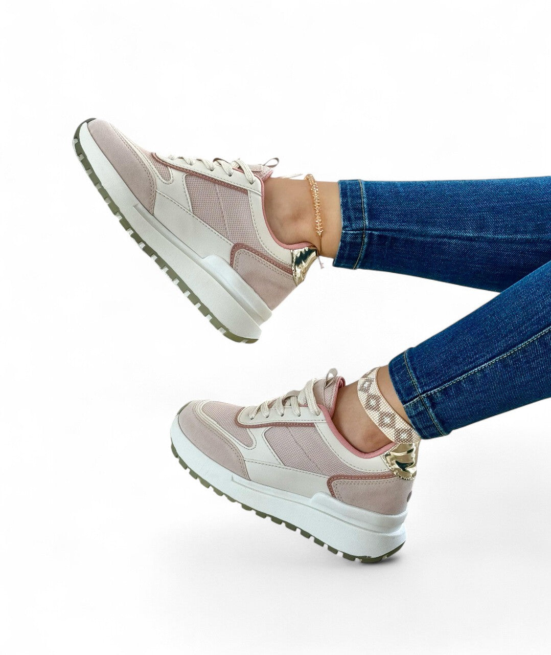 Pink sneakers with white soles worn by a person on a white background