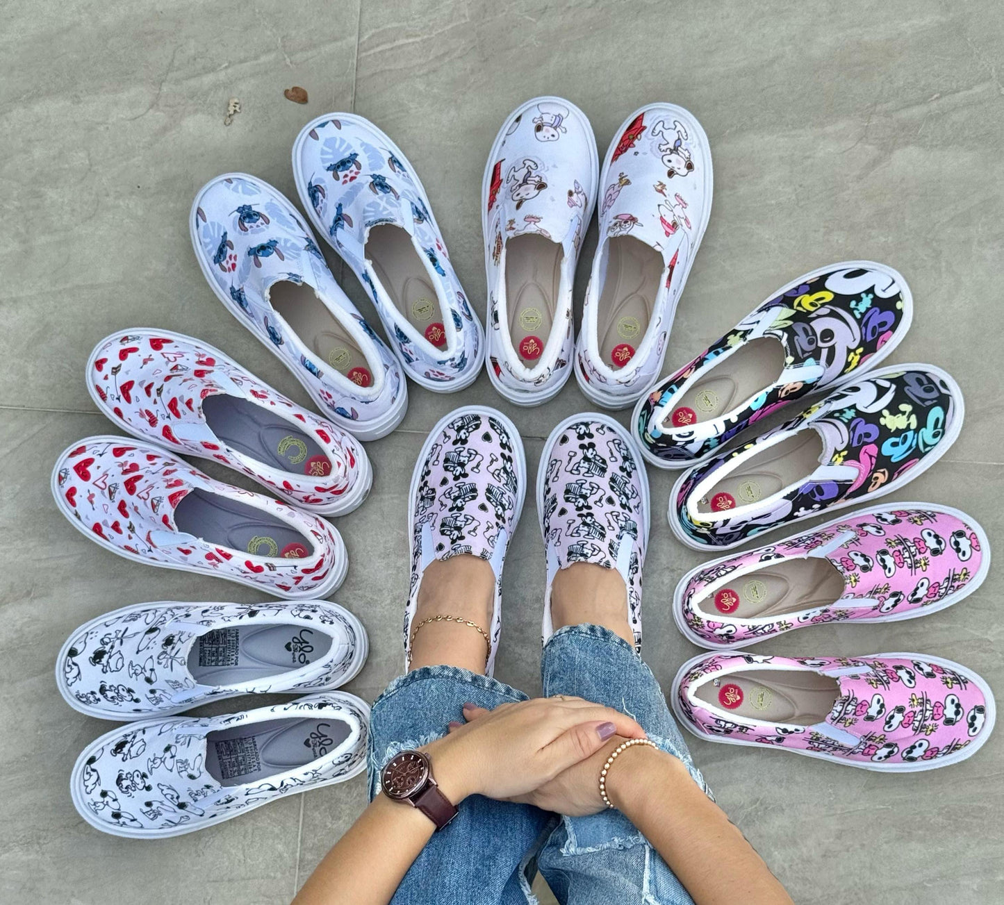 Person wearing floral shoes arranged in a circle on concrete.